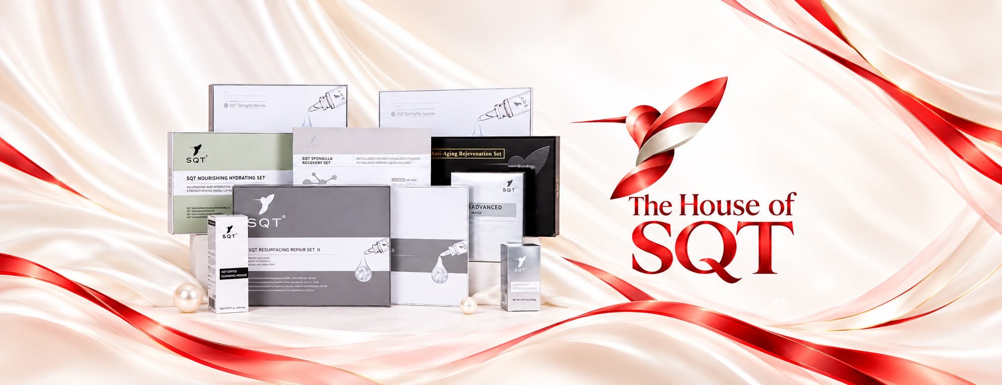 The House of SQT — the SQT professional product collection, including the Nourishing Hydrating, Resurfacing Repair, Spongilla Recovery and Anti-Aging Rejuvenation sets, arranged on ivory silk beside the red hummingbird emblem